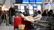 Reisende warten auf ihren Flug, nachdem Beschäftigte der Abfertigung des Flughafens seit heute morgen für bessere Löhne streiken