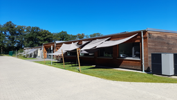 Das Tierheim Coesfeld, ein Holzbau mit Sonnensegeln vor den Fenstern