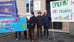 Ulf Allhoff-Cramer steht mit anderen Demonstranten vor dem Gericht