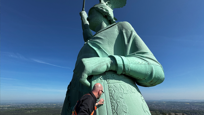 Ein Mann tastet das Hermannsdenkmal ab | Bildquelle: WDR Ein Mann tastet das Hermannsdenkmal ab