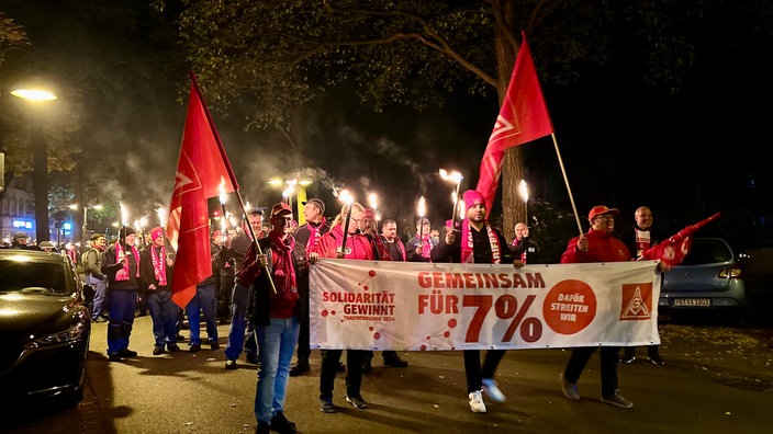 Fackelmarsch der Kollegen aus dem Paderborner Werk. Sie halten auch ein Plakat für sieben Prozent mehr Lohn.