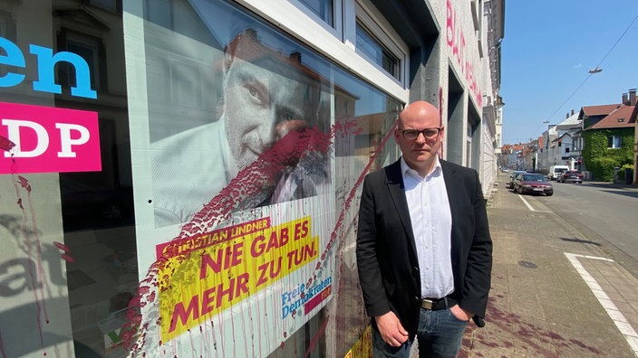 Jan Maik Schlifter vor beschmiertem FDP-Büro