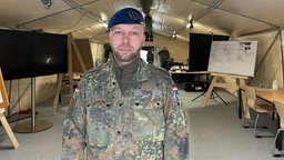 Ein Soldat in einem Raum mit weiteren Soldaten