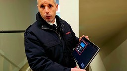 Feuerwehrmann zeigt uns auf dem Tablet die Software der Brandmeldeanlage