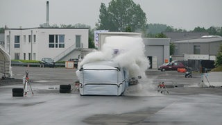 LKW fährt in mobile Sperre, die mit Wasser gefüllt ist, für einen Crashtest