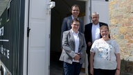 Das Foto zeigt die Verantwortlichen der Tiny Church vor dem Anhänger, in dem sich die Tiny Church befindet