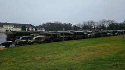 Militärfahrzeuge geparkt auf Kasernengelände.