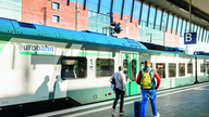 Zwei Männer auf dem Bahnsteig neben der Eurobahn