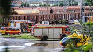 Feuerwehr und Rettungshubschrauber stehen vor den Zügen am Güterbahnhof