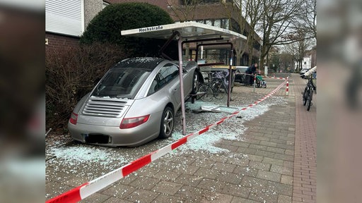 Ein silberner Porsche hängt in den Überresten der Bushaltestelle "Hochstraße" in Münster Quelle: privat