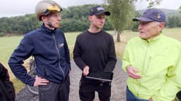 Drei Männer auf der Straße mit fehlendem Radweg.