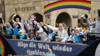 Junge Jecken und Jeckinnen jubeln auf einem Karnevalswagen, der am Rosenmontag über den Prinzipalmarkt fährt.