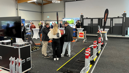 Konferenzteilnehmer sehen sich Videos vergangener Crash Tests an