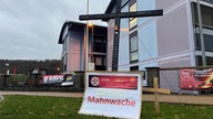 Schild für Mahnwache mit zwei Kreuzen 