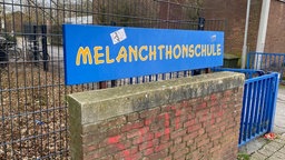 Schild mit der Aufschrift Melanchthonschule vor einem Schultor