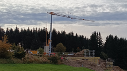 Baukran auf einer Wiese an einer Baustelle in Winterberg