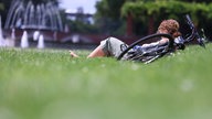 Eine Frau aus Wuppertal in Nordrhein-Westfalen genießt eine Pause und die Sonne im Nordpark Düsseldorf