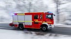 Blick auf ein Fahrzeug der Feuerwehr im Einsatz mit Blaulicht