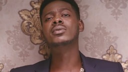 Adekunle Gold - Videostill "Sade" - der Sänger vor einer Goldtapete