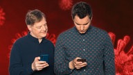 COSMO Tech - Alles, was ihr über Corona-Apps wissen müsst, Jörg Schieb und Dennis Horn testen App, im Hintergrund corona-viren