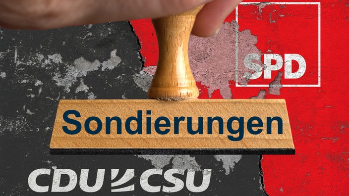 Ein symbolischer Holzstempel mit der Aufschrift "Sondierungen", gehalten von einer Hand, vor einer Wand mit den Logos von CDU / CSU (Union) und SPD auf den abgeplatzten Farben Schwarz und Rot sowie einem dicken Riss.