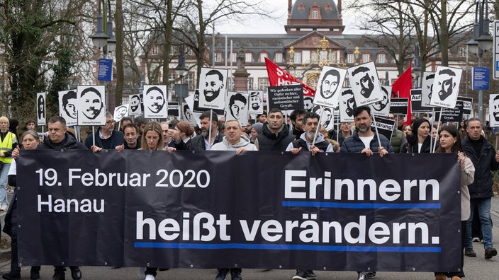 Menschen nehmen an einer Demonstration in Gedenken an den rassistischen Anschlag in Hanau vom 19.02.2020 teil