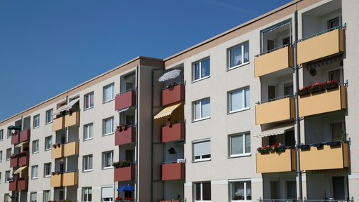 Außenansicht einer Fassade eines Mehrfamilienhauses vor blauem Himmel