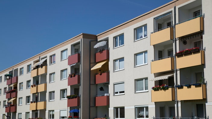 Außenansicht einer Fassade eines Mehrfamilienhauses vor blauem Himmel