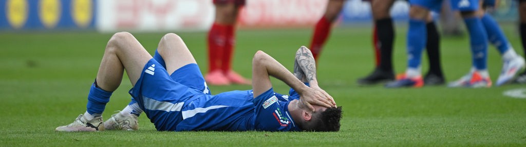 Un calciatore italiano disperato a terra dopo la sconfitta contro la Svizzera