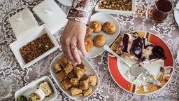 Speisen zum Zuckerfest liegen auf einem aufbedeckten Tisch