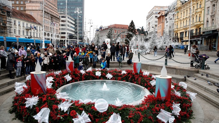 Atmosfera božićnog marketa i ukrašena fontana 