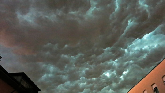 Häuser vor dunklen Unwetterwolken