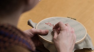 Kraft tanken! - Langer Donnerstagt im Museum Ludwig mit "feministischem Sticken" - eine Frau stickende Frau, Detailblick  auf die Hände.