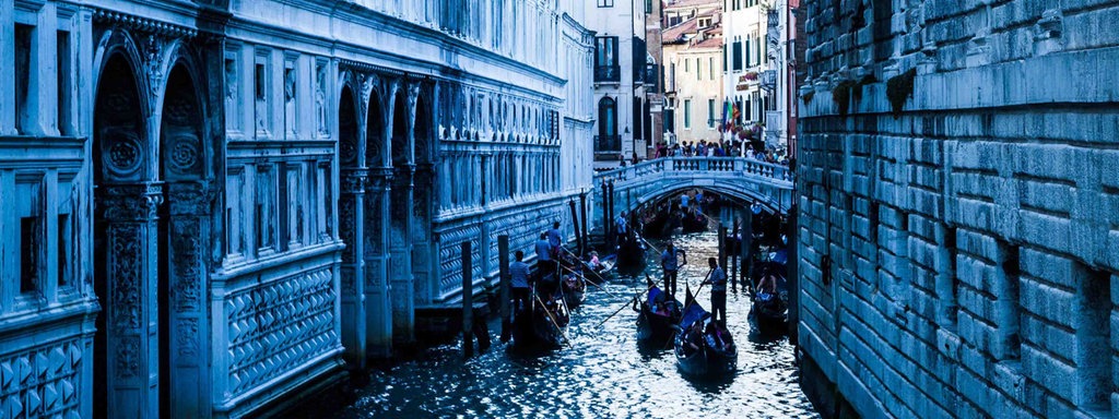 Eine Brücke in Venedig, unter der Gondeln herfahren.