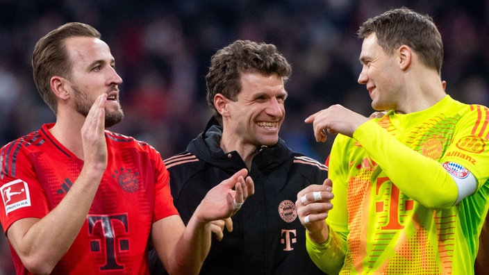 Bayerns Thomas Müller (m) lacht und jubelt mit Harry Kane (l.) und Manuel Neuer (r) (Nahaufnahme)