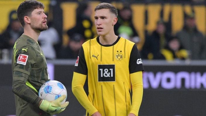 Spielszene: Dortmunds Torwart Gregor Kobel (l) hält den Ball in der Hand, Teamkollege Nico Schlotterbeck (r.) sieht in an (Nahaufnahme)