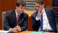 Marcus Optendrenk, Finanzminister des Landes Nordrhein-Westfalen (l, CDU), und Hendrik Wüst, Ministerpräsident von NRW (r) beraten sich im Landtag von Nordrhein-Westfalen 