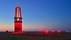 Blick auf die Halde Rheinpreussen bei Sonnenuntergang, mit der großen, roten Kunstinstallation "Das Geleucht", in der Form einer Grubenlampe