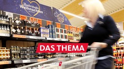 Eine Kundin schiebt einen Einkaufswagen an einem Regal mit Delikatessen in einem Discounter in Ratingen vorbei.