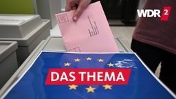 Ein Wahlbrief mit einem Stimmzettel für die Europawahl wird in einem Wahllokal für die Briefwahl in eine Wahlurne gesteckt 