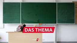 Klassenzimmer mit leerer Tafel und leerem Lehrerpult