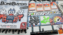 Die Spieleschachte von Bomb Busters auf dem Spielbrett mit Zünder, daneben ein Kartenhalter, der verschiedene Kabel mit Zahlenwerten zeigt