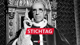 Papst Pius XII. hebt die rechte Hand mit dem Ring des heiligen Petrus, um einen Segen zu sprechen.