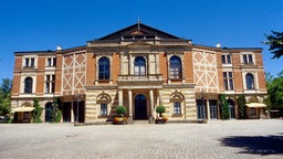 Blick auf die Festivalhalle der Bayreuther Festspiele bei Sonnenschein.