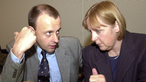 Friedrich Merz spricht mit Angela Merkel. 