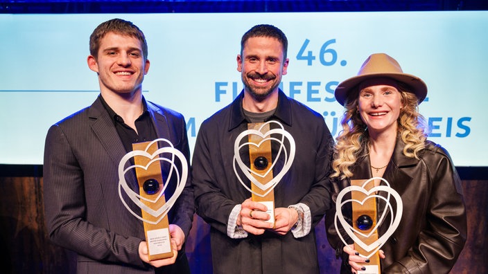 Regisseur Lauro Cress (M) steht nach dem Gewinn des 46. Filmfestival Max Ophüls Bester Spielfilm für seinen Film "Ungeduld des Herzens" auf der Bühne, neben ihm die besten Nachwuchsdarsteller Ladina von Frisching und Giulio Brizzi.