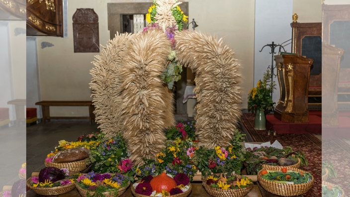 festliche Erntekrone mit zahlreichen Gaben beim Erntedankfest