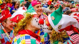 Bunt kostümierte Karnevalisten feiern Karneval in Köln.