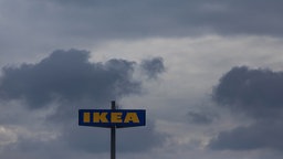 Ein IKEA Fimenschild vor dunklen Wolken.