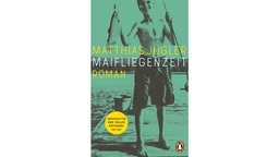 Das in grün gehaltene Buchcover "Maifliegenzeit" von Matthias Jügler zeigt einen Jungen auf einem Steg, der lachend einen Fisch an der Angel zeigt.